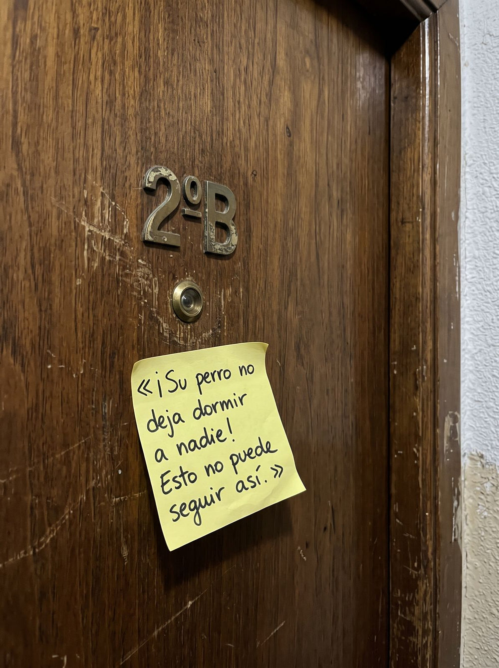 Nota de un vecino pegada en la puerta quejándose del perro